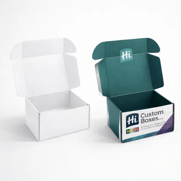 Two open cardboard mailer boxes- one plain white and one with dark teal interior printing- class=